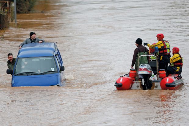 Firemen rescuing men in sinking van, Gloucester, England, 2012