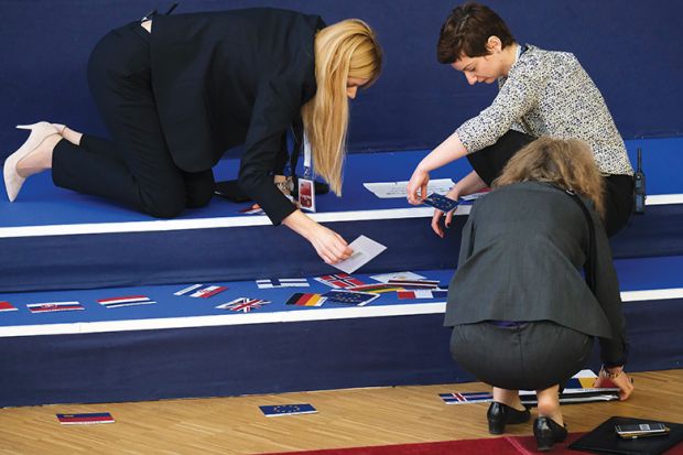 Workers sort flags to mark the spots where European leaders will stand for the family photo during EU summit on March 22, 2019 in Brussels, Belgium