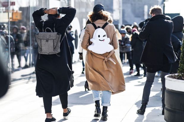 A girl wearing a backpack with a smiley face on it