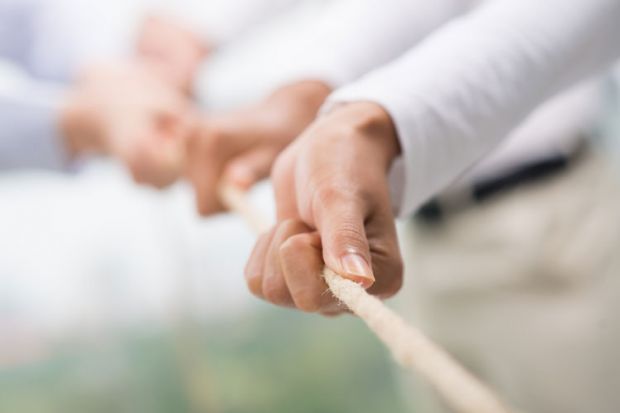 Hands pulling rope, tug of war, teamwork