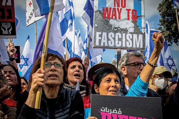 Protesters hold Israeli flags and placards while chanting slogans during the demonstration