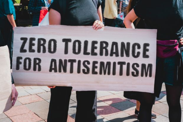 Protesters with a sign saying "Zero tolerance for antisemitism"