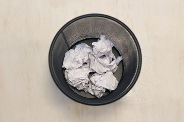 Wastepaper bin from above, with scraps of paper in it