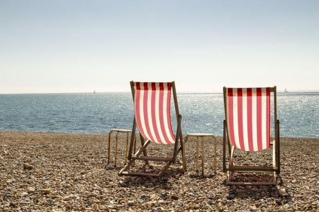 Two empty deckchairs on a stony beach to represent brain drain of graduates from English coastal towns 