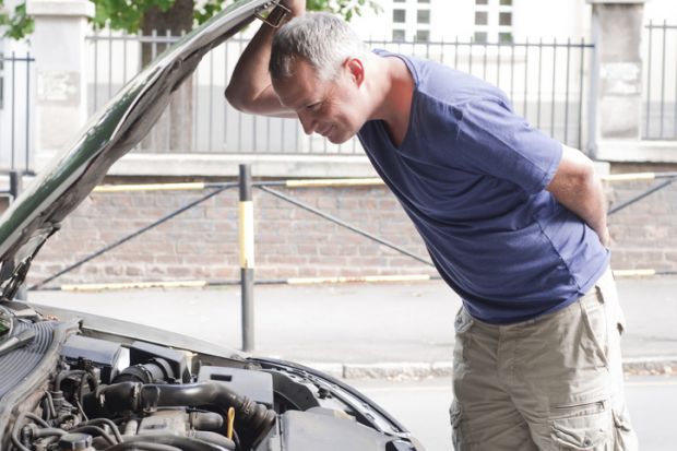 Inspection, man looking under car bonnet 