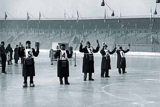 Judges hold up their score cards on the ice