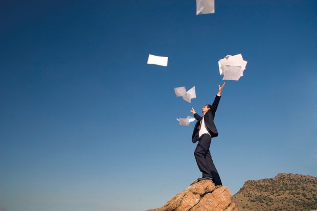 man throws papers in the air