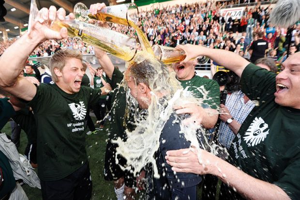 Men pouring beer over each other