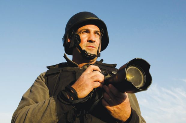 Male war photographer wearing protective helmet and vest