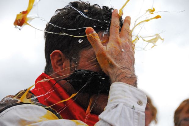 Man cracking egg on forehead