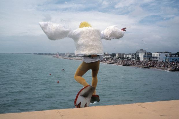 Man dressed as bird jumping into sea, Bognor Regis, England