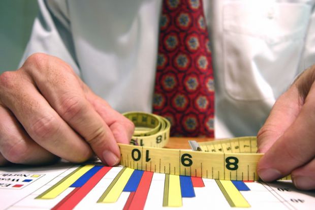 Man measuring bar graphs with tape measure