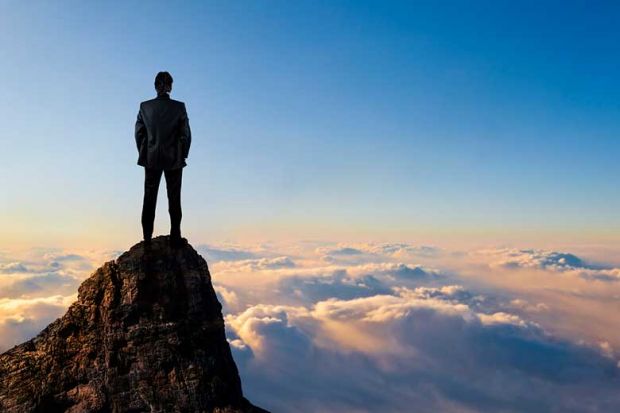 Man on top of mountain above clouds