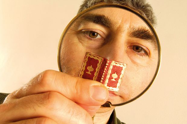 Man reading tiny book