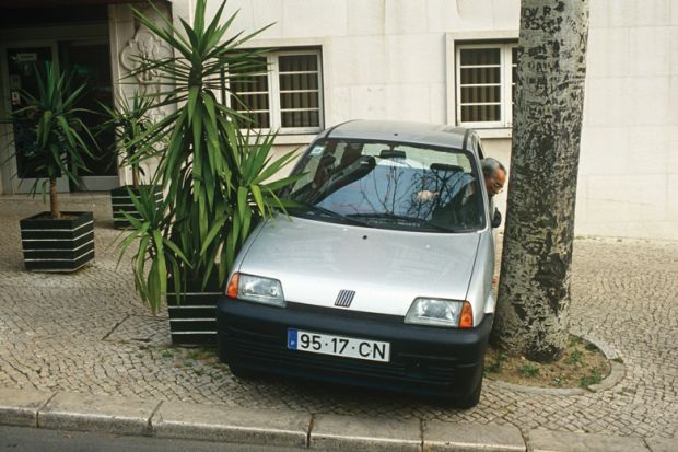 Man reverses his car into a narrow space