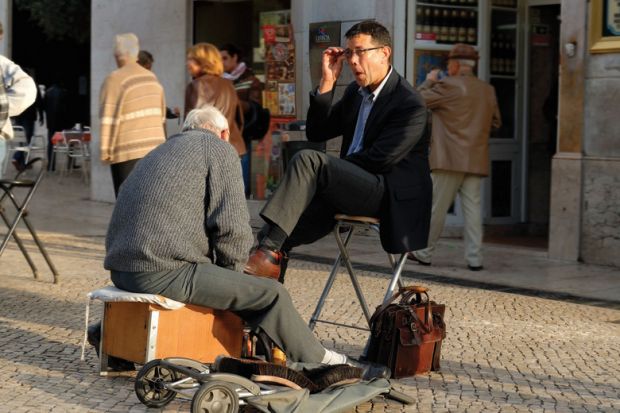 Man shining the shoes of a businessman