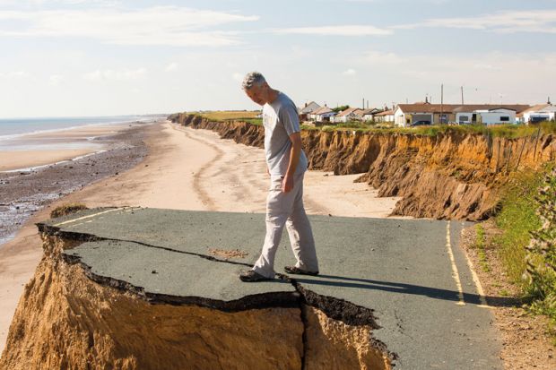 Man standing on the edge of an eroded cliff