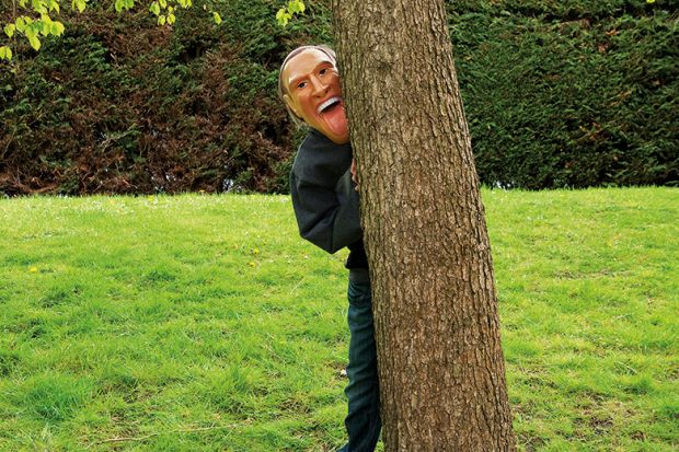 Man wearing mask behind tree