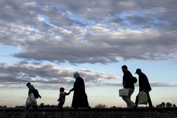 Migrants walk along rail tracks, Roszke, Hungary, 2015