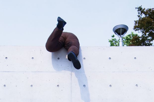 Overweight man scrambling over high wall