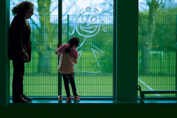 Child drawing in window