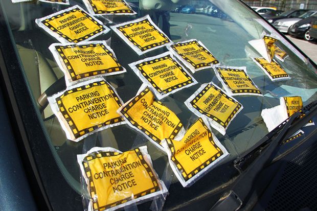 Car with bonnet covered in parking infringement stickers