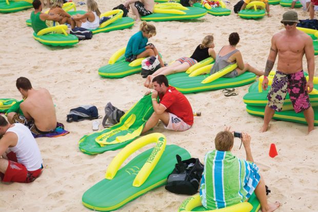 People sitting on the beach on giant lilos