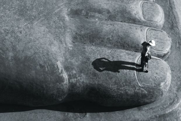 Person standing on big toe of sitting Buddha statue, Leshan