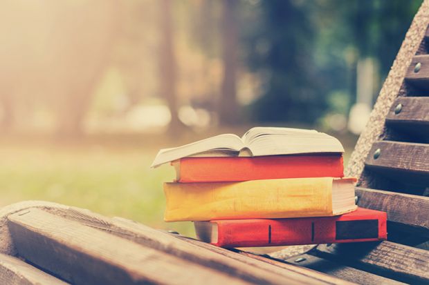 Pile of books on park bench