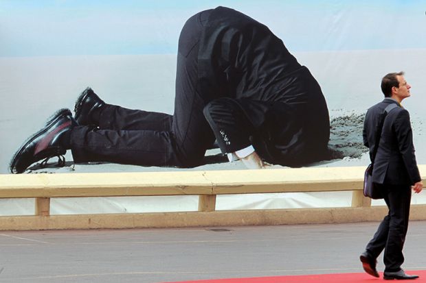 Poster of man with head buried in sand