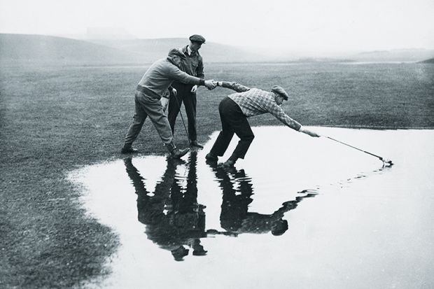 men reaching in pond