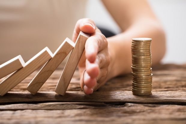 dominoes falling onto a pile of coins