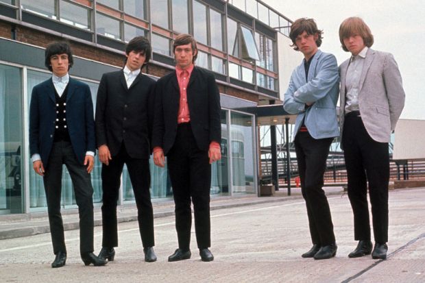 Rolling Stones posing beside airport runway