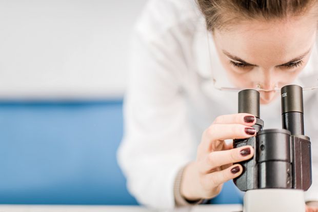 Scientist looking into microscope