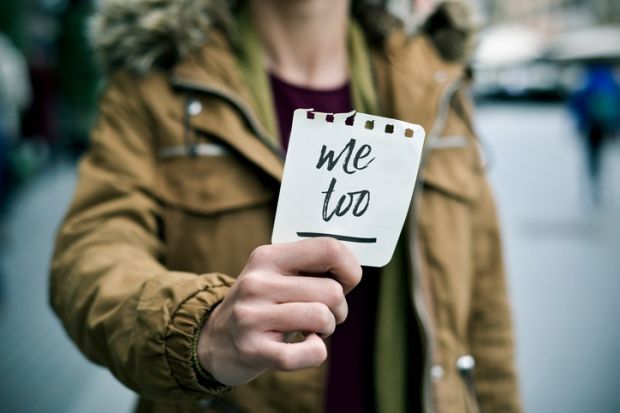 Woman holding a "me too" sticker