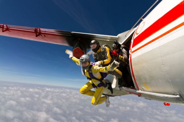 Three sky divers jumping out of a plane