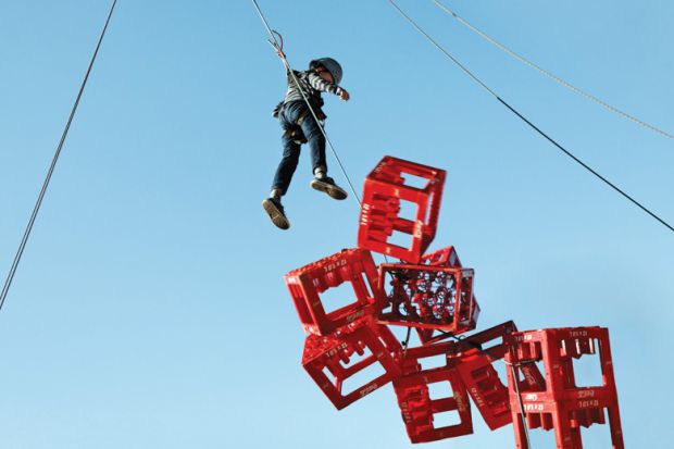 Boy hangs above collapsing crates