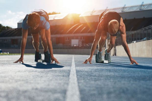 Sprinters on starting blocks at sunrise