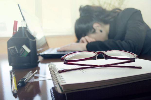 Stressed woman with head on desk