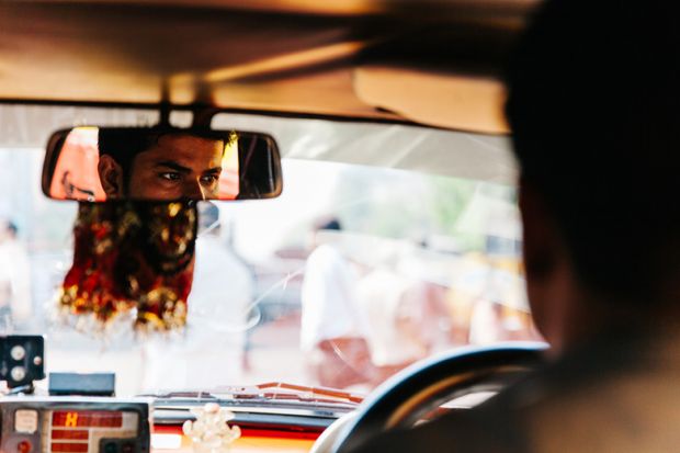 Taxi driver reflected in the rearview mirror