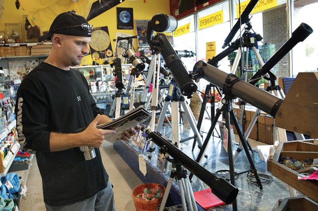 man in telescope shop