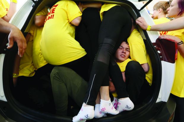 Group of students squeeze into a car