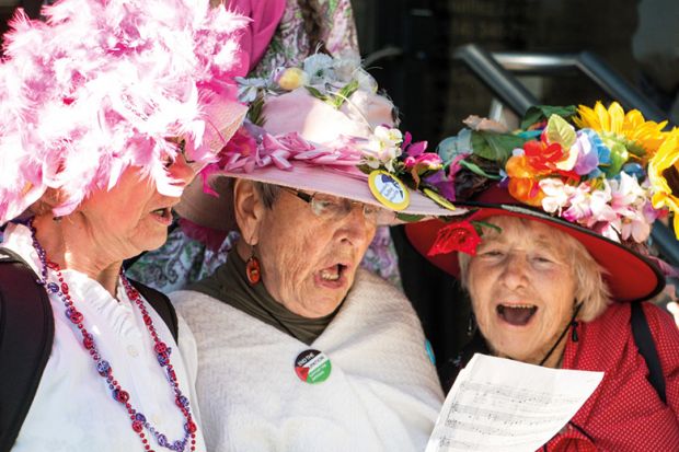 Three women singing from same hymn sheet