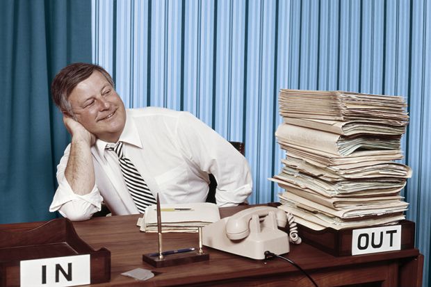 Office worker satisfied with full out tray and empty in tray on desk