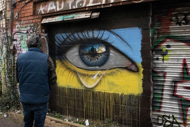 People pass a mural of president of Ukraine Volodymyr Zelenskyy, by the artist Aches, in central Dublin