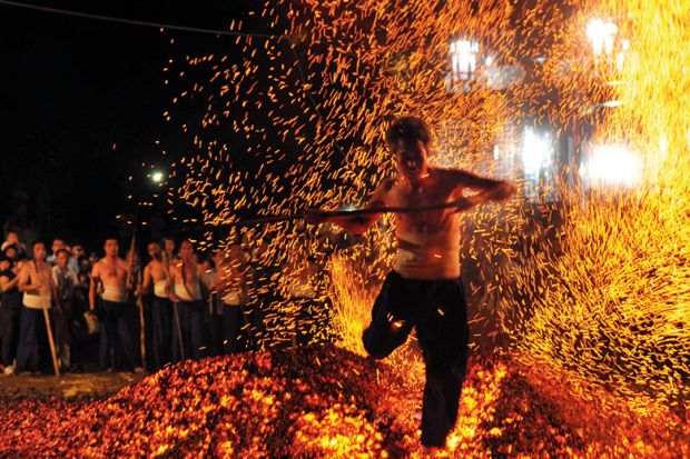 A man walking over burning coals