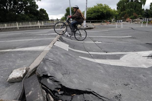 Tania Flowers rides her bike onto a damaged bridge over the Avon River to illustrate New Zealand scraps research reforms and infrastructure funding