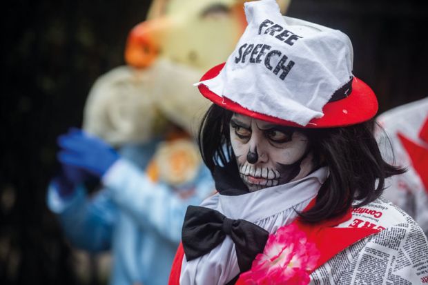 Protester wearing free speech hat in London to illustrate The free speech bill has finally become law - what happens next?