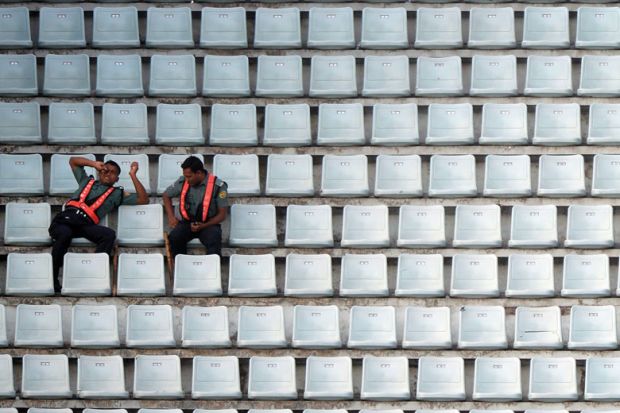 Officials sit among empty benches during the ninth match of the Asia Cup one-day cricket tournament to illustrate Indian PhD diaspora leaves universities short of recruits