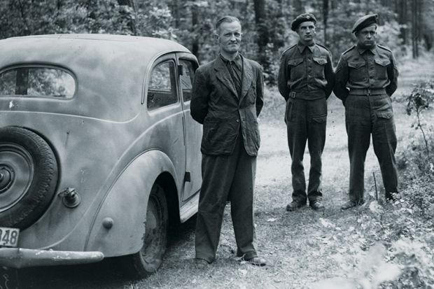 William Joyce (Lord Haw-Haw) guarded by soldiers, Germany, 1945